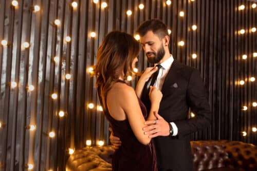 Elegant couple standing close under warm lights, representing romantic connection and girlfriend experience escorts in London