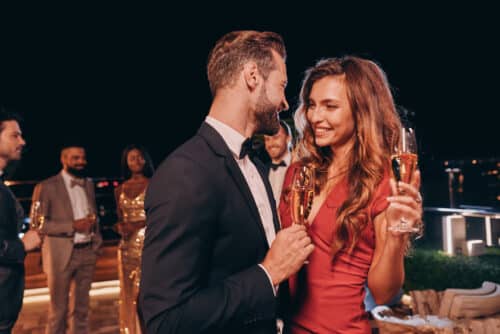Elegant couple enjoying champagne at a rooftop evening event in London, representing the refined social experiences offered by professional escorts